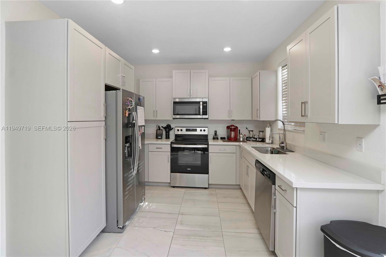 2432 Southeast 10th Street Homestead, FL 33035 - Photo 11 of 30 a kitchen with a sink a microwave a refrigerator and cabinets
