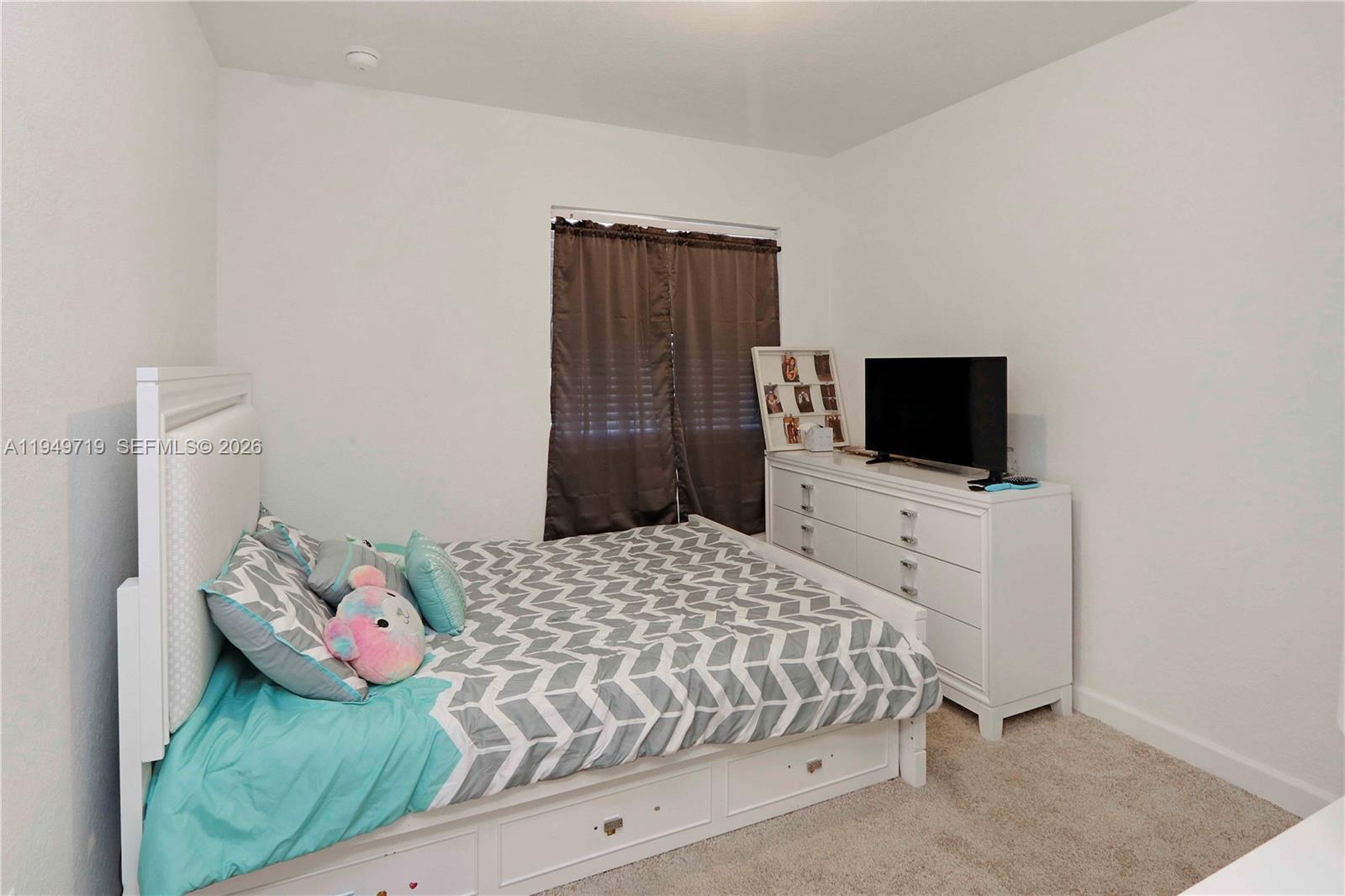 2432 Southeast 10th Street Homestead, FL 33035 - Photo 14 of 30 a bedroom with a bed and a flat screen tv