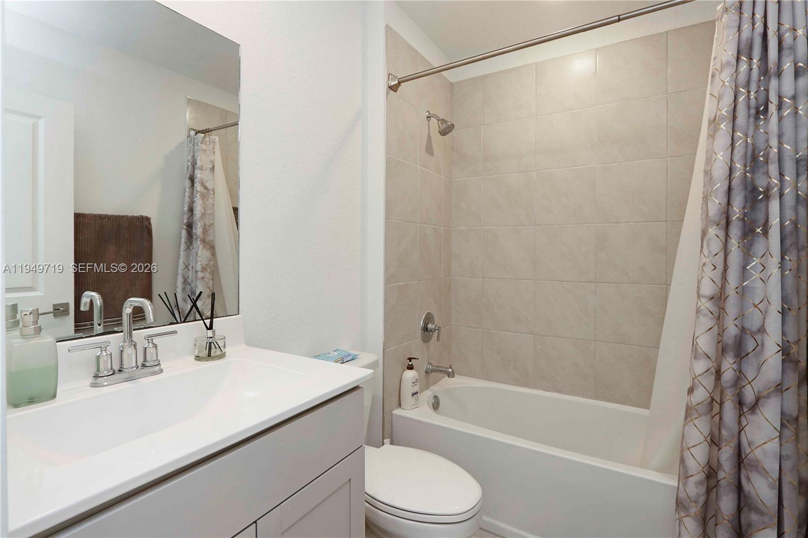 2432 Southeast 10th Street Homestead, FL 33035 - Photo 18 of 30 a bathroom with a sink a toilet a mirror a bathtub and shower