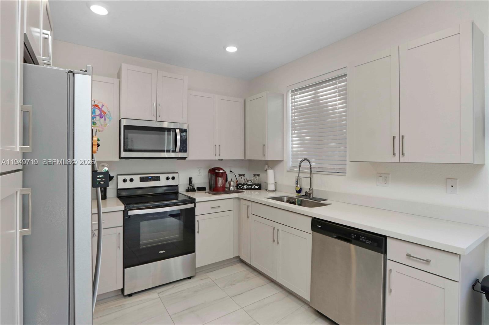 2432 Southeast 10th Street Homestead, FL 33035 - Photo 10 of 30 a kitchen with white cabinets sink and stainless steel appliances