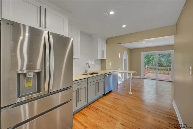 a large kitchen with stainless steel appliances a refrigerator and a stove top oven