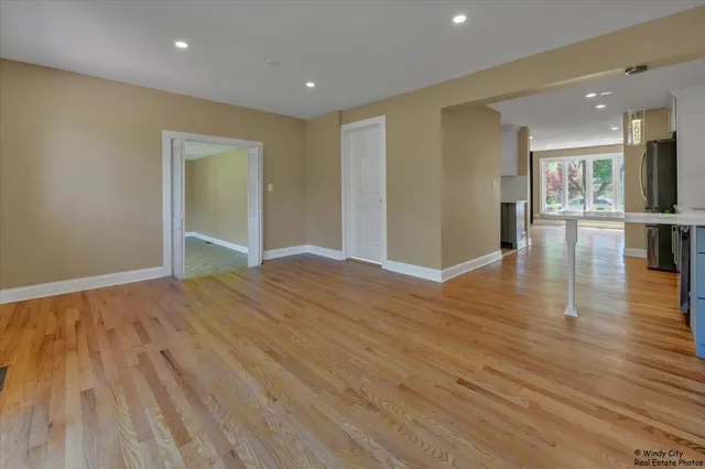 a view of empty room with wooden floor and furniture