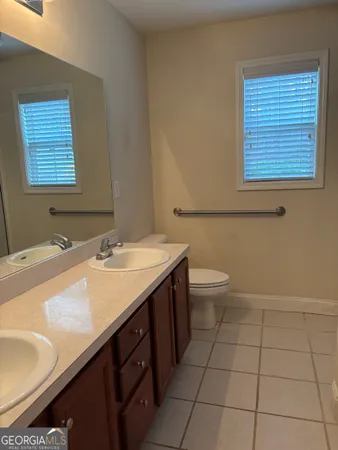 a bathroom with a sink a toilet and a mirror
