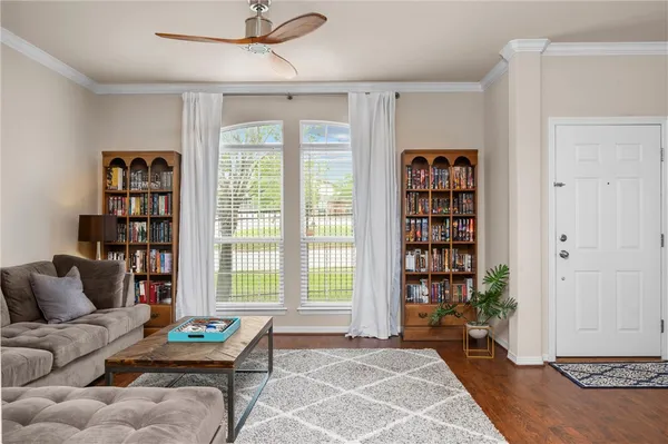 a living room with furniture a bookshelf and a window
