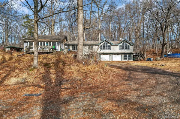 a front view of a building with large trees