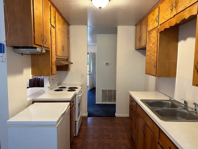 a kitchen with a sink stove top oven and cabinets