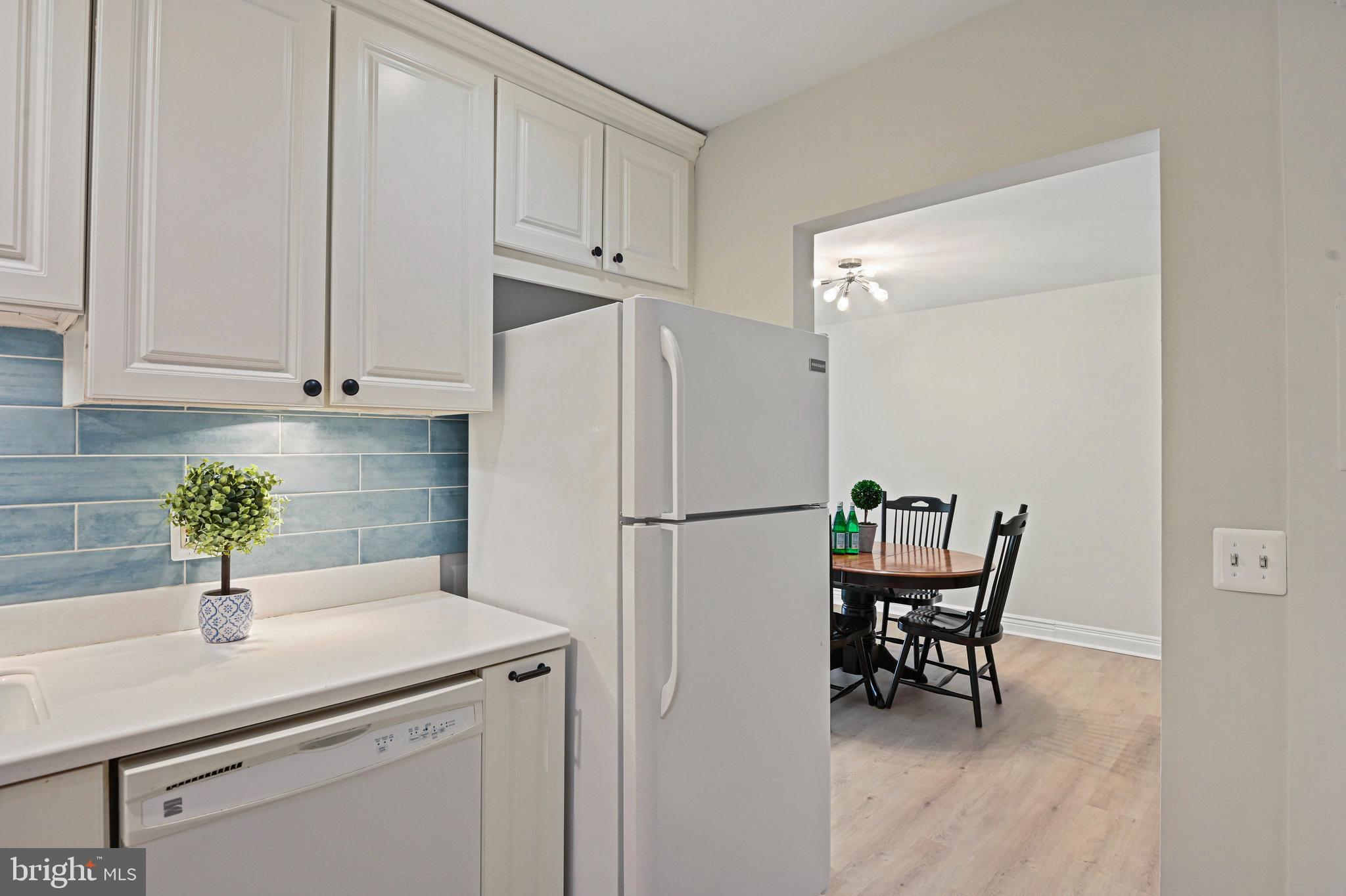 11625 Vantage Hill Road, Unit C Reston, VA 20190 - Photo 11 of 35 a white kitchen with a refrigerator a sink and white cabinets