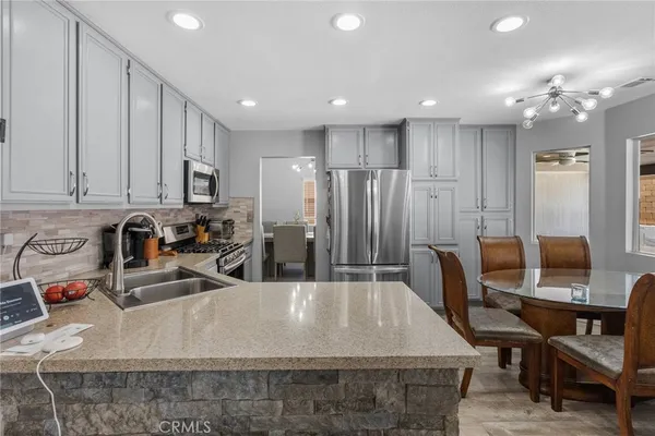 a large kitchen with kitchen island a sink table and chairs