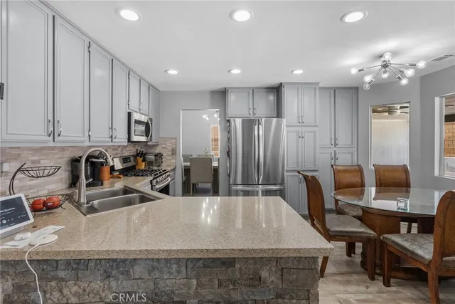 a large kitchen with kitchen island a sink table and chairs