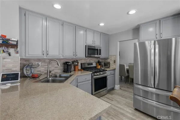 a kitchen with granite countertop a refrigerator stove and sink