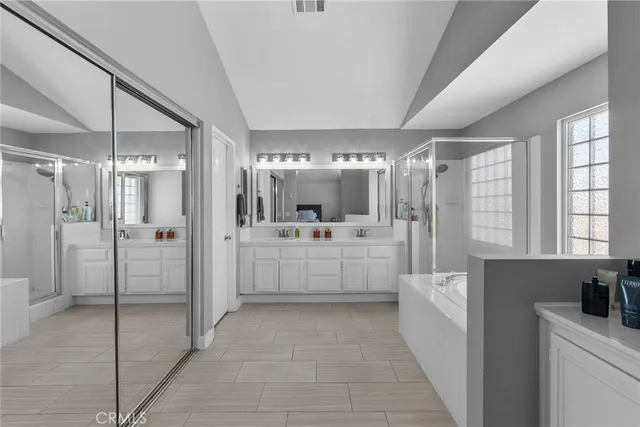 a large white bathroom with a tub a shower and sink