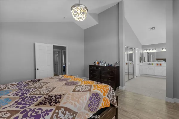 a bedroom with a bed and a chandelier