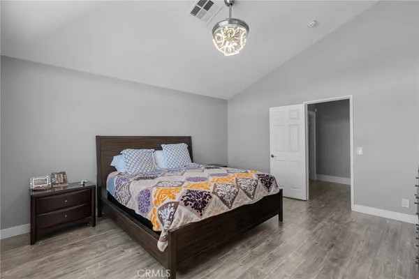 a bedroom with a bed and a wooden floor