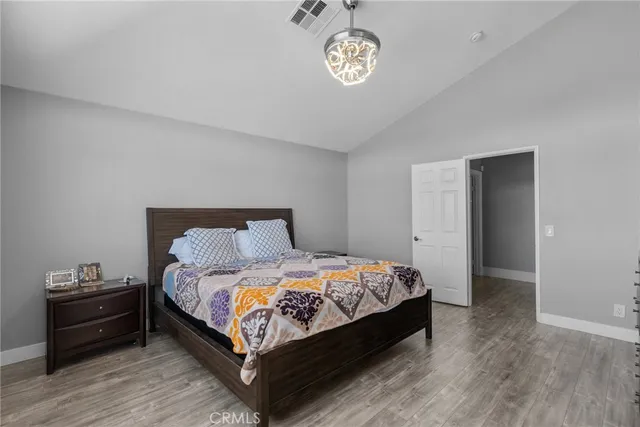a bedroom with a bed and a wooden floor