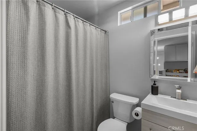 a bathroom with a toilet a sink and curtain