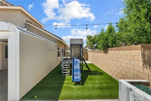 a view of a backyard with plants and wooden fence