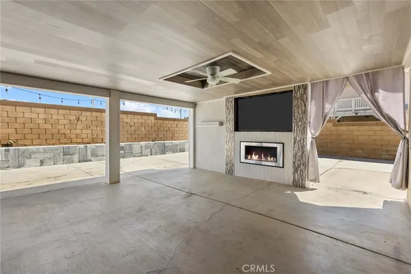a view of an empty room with a fireplace and a large window