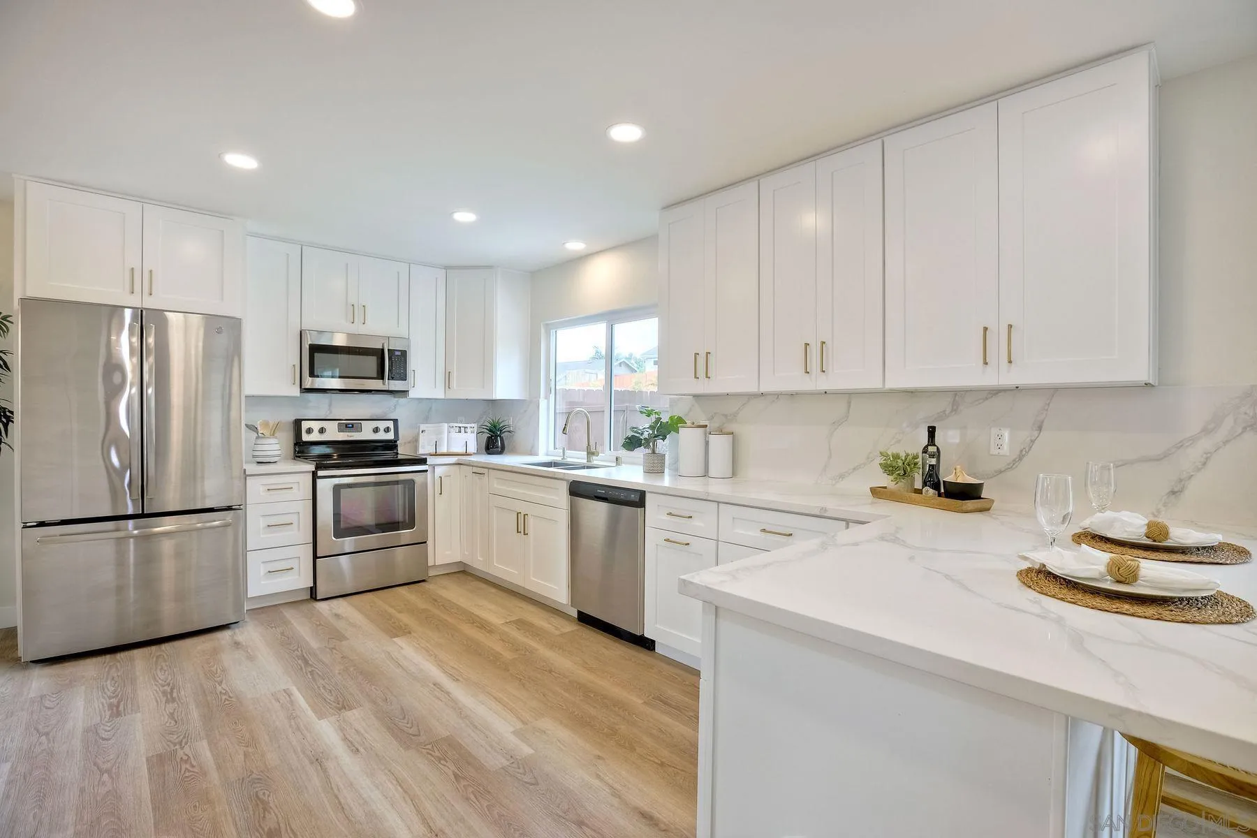 3577 Winslow Road Oceanside, CA 92056 - Photo 16 of 42 a kitchen with a refrigerator a stove a sink and white cabinets