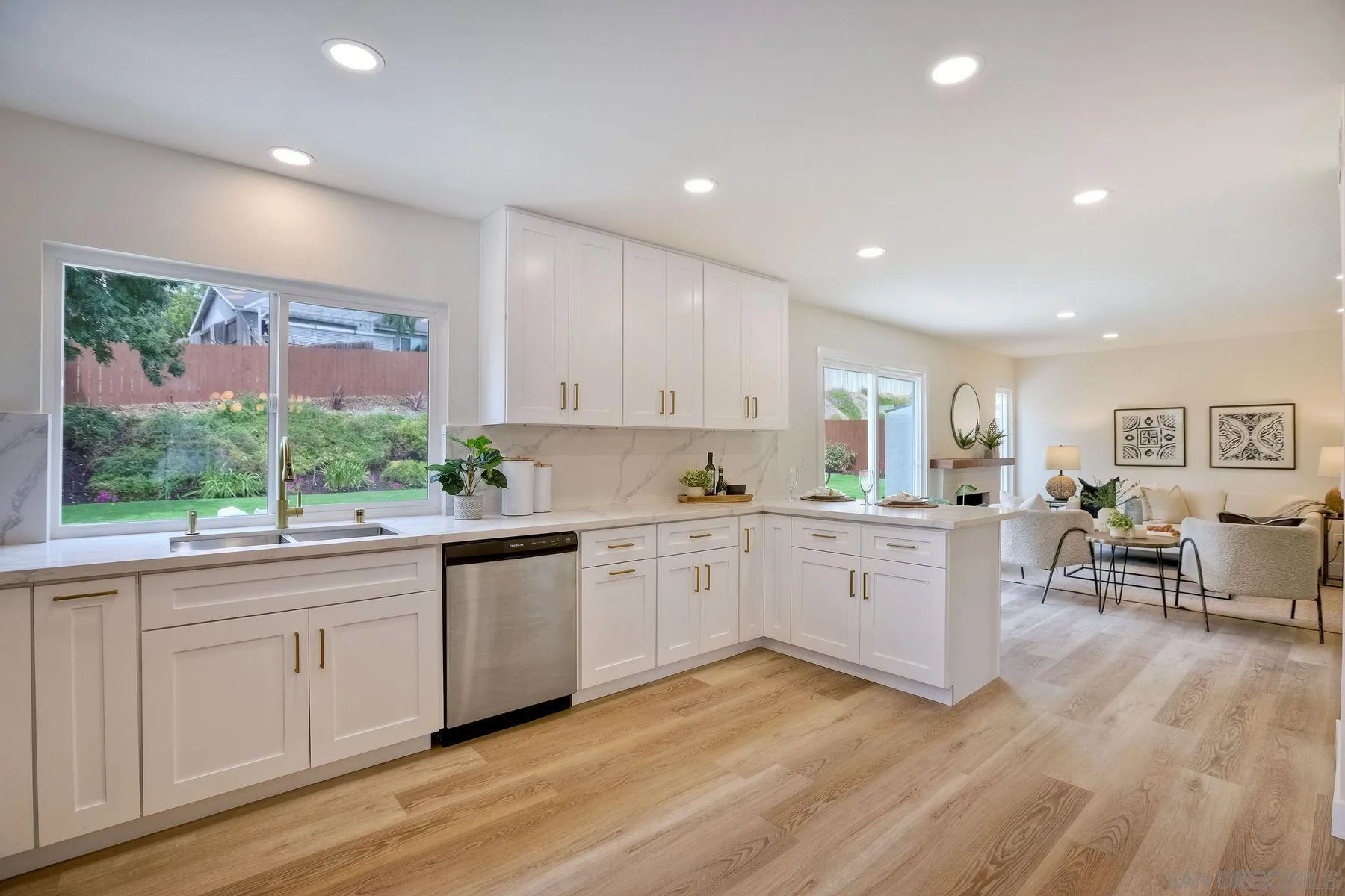 3577 Winslow Road Oceanside, CA 92056 - Photo 19 of 42 a kitchen with wooden floors and white cabinets
