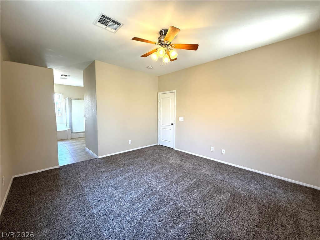 5942 Rampolla Drive Las Vegas, NV 89141 - Photo 14 of 27 A well-lit bedroom features plush carpeting and a convenient ceiling fan.