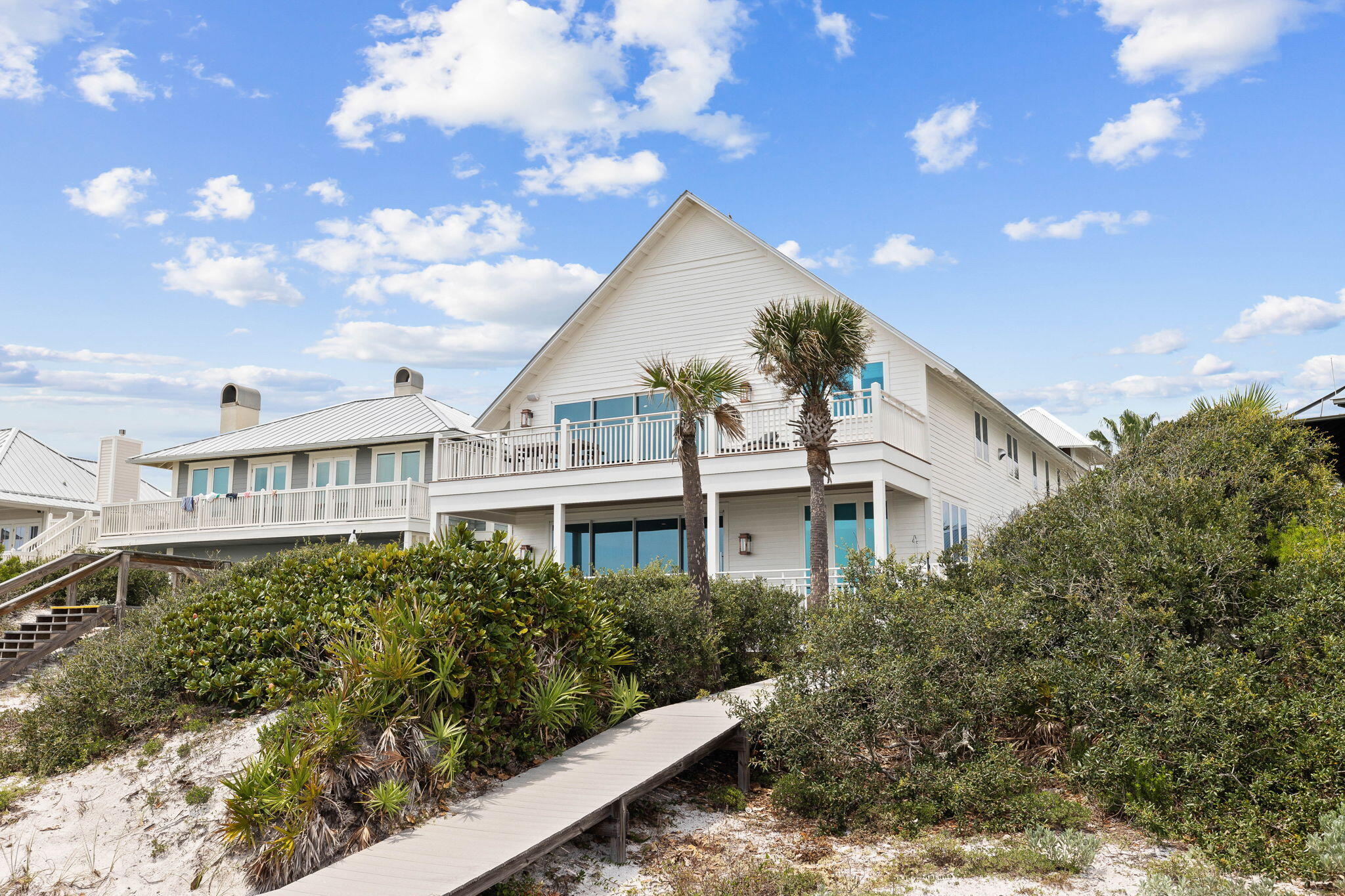 357 Old Beach Road Santa Rosa Beach, FL 32459 - Photo 104 of 106 a view of a white house next to a yard with plants and trees