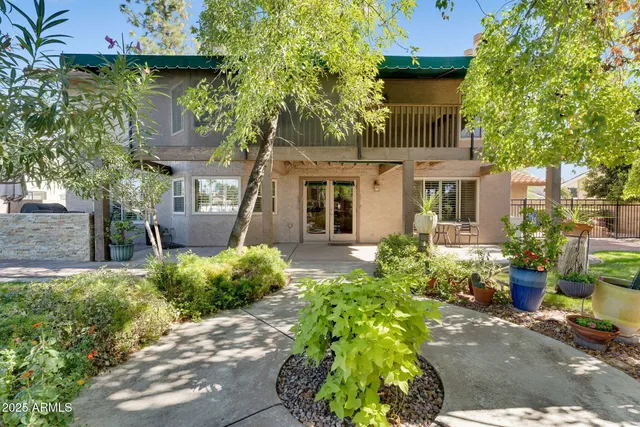 a view of a patio with a table and chairs under an umbrella with wooden fence