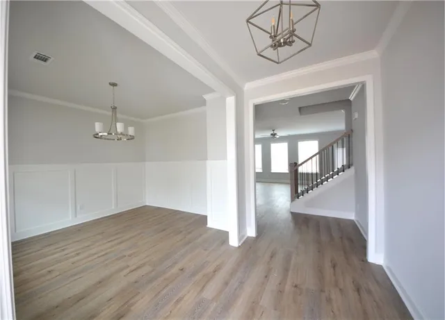 an empty room with wooden floor fireplace and windows
