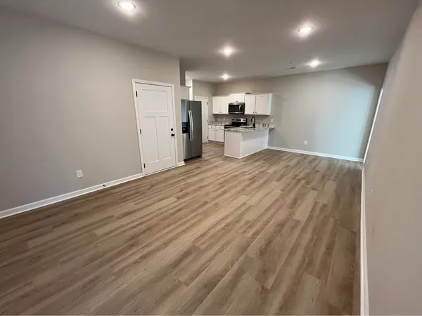 a view of empty room with wooden floor