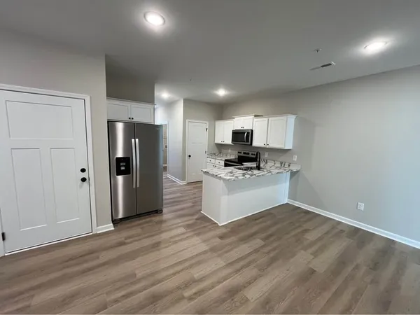 a kitchen with white cabinets and stainless steel appliances
