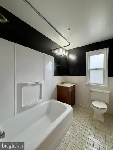 a bathroom with a tub sink and toilet