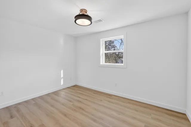 a view of a room with wooden floor and white walls