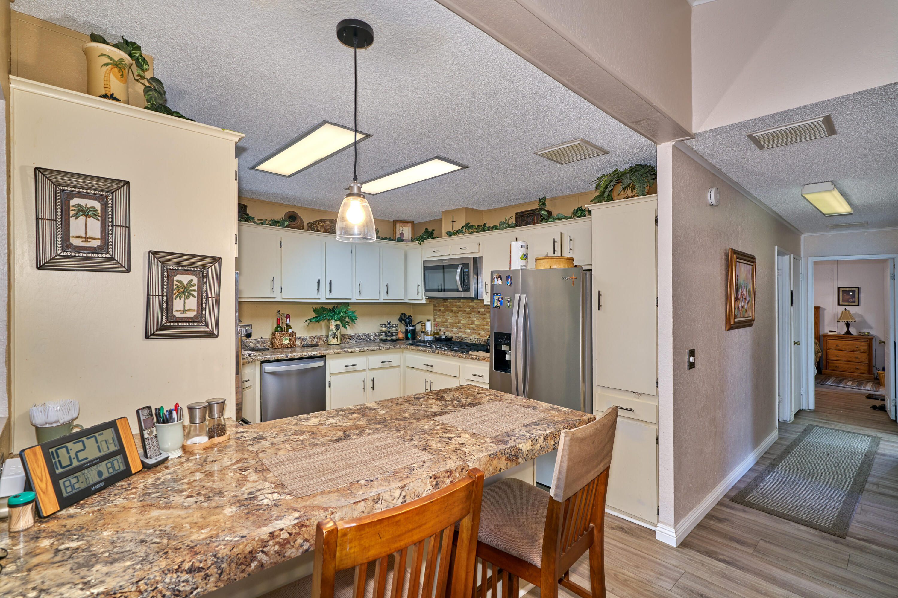 33537 Lisa Circle Thousand Palms, CA 92276 - Photo 12 of 35 a kitchen with stainless steel appliances granite countertop a refrigerator a oven a sink a dining table and chairs with wooden floor