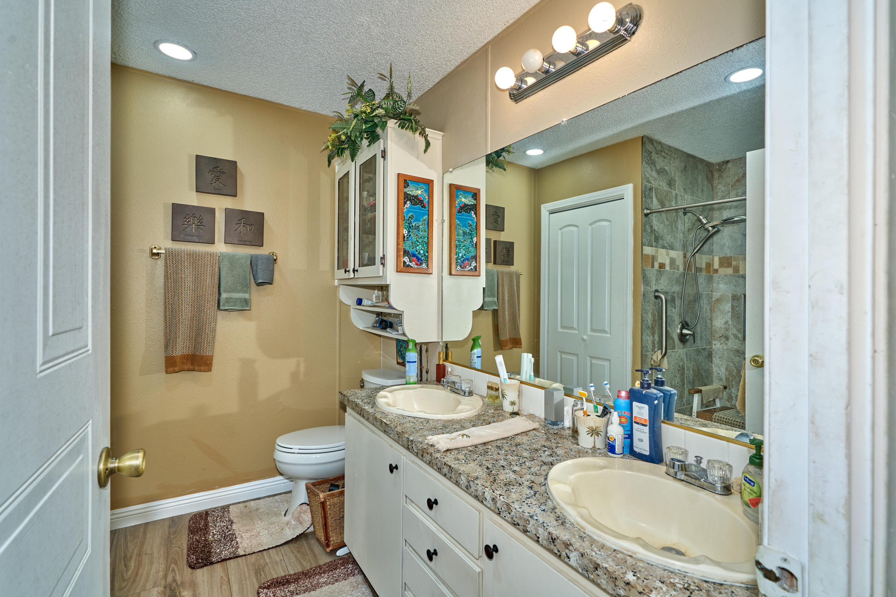 33537 Lisa Circle Thousand Palms, CA 92276 - Photo 14 of 35 a bathroom with a granite countertop sink a toilet a mirror and shower