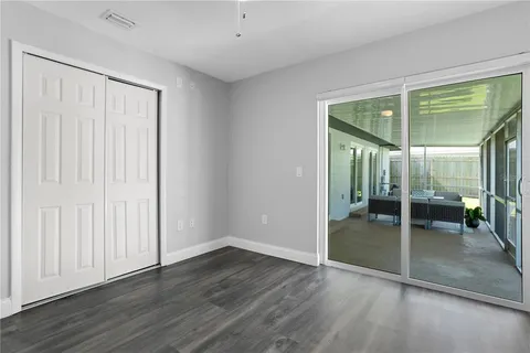 an empty room with wooden floor and door