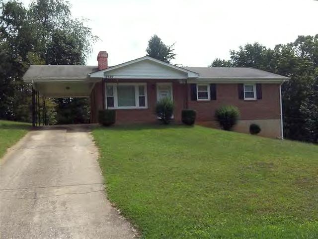 a front view of a house with a garden and yard
