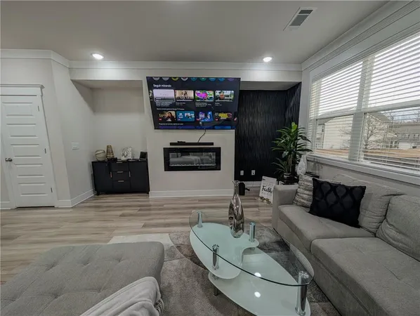 a living room with furniture a flat screen tv and a large window