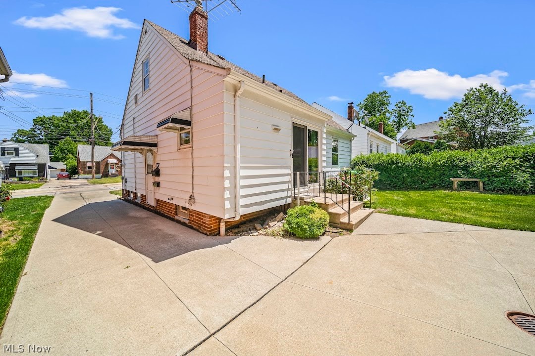 View of property exterior featuring a lawn