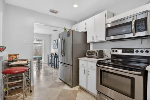 a kitchen with stainless steel appliances granite countertop a stove microwave and refrigerator