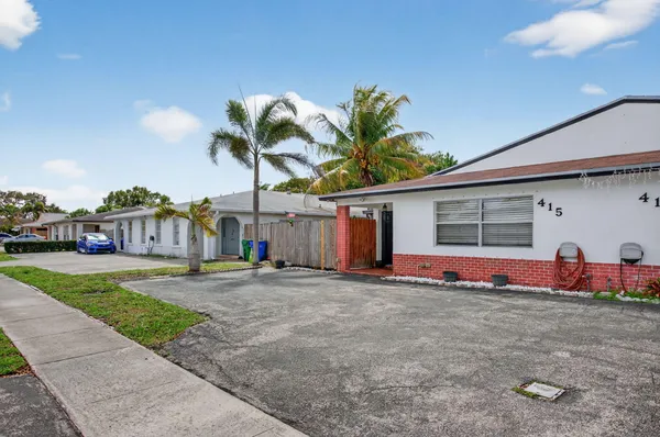 a view of a house with a backyard and road