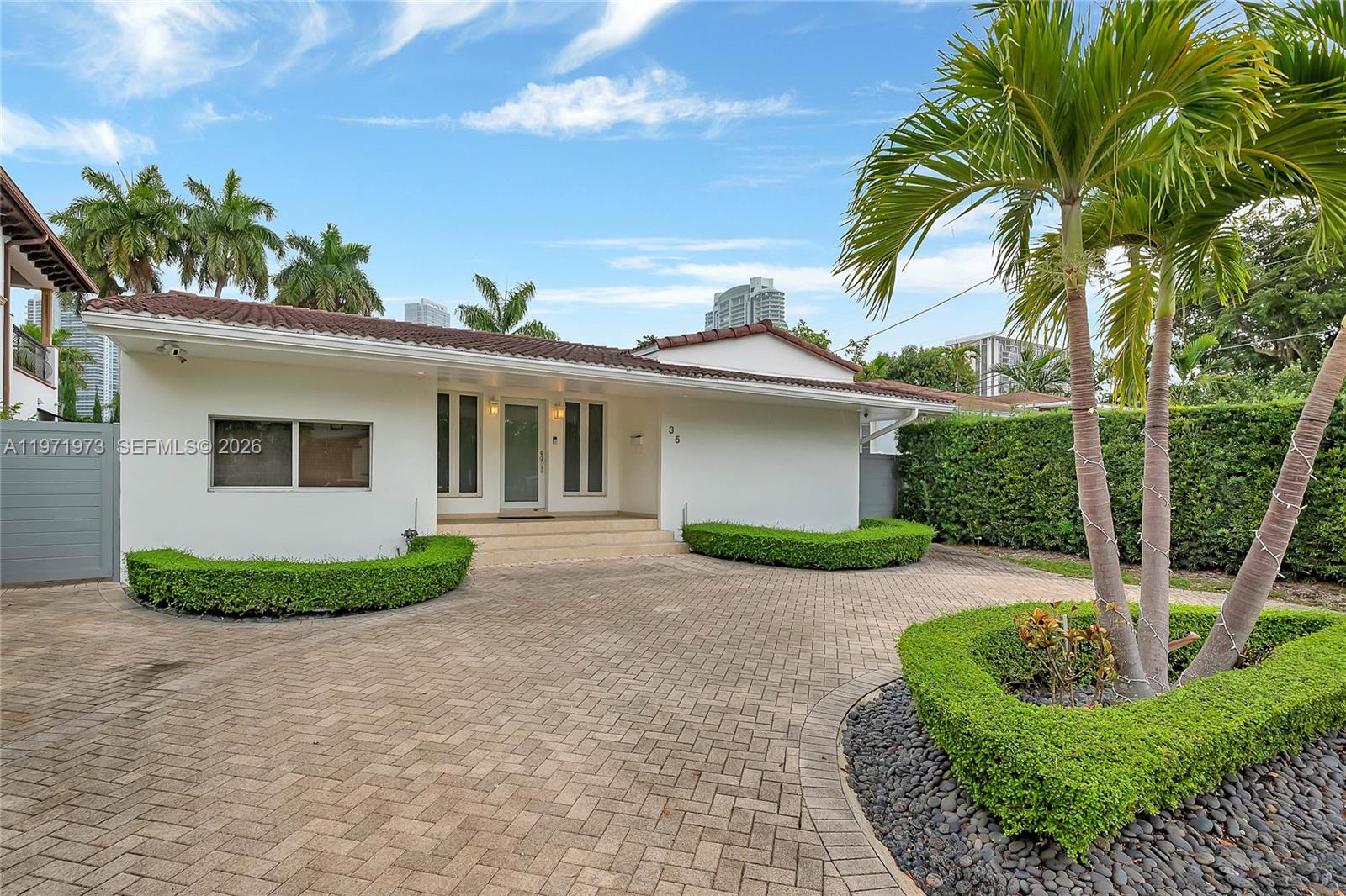 a front view of a house with garden and plants