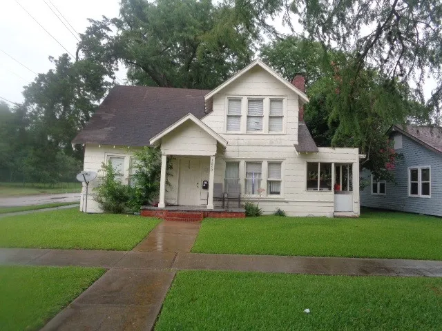 a front view of a house with a yard and trees