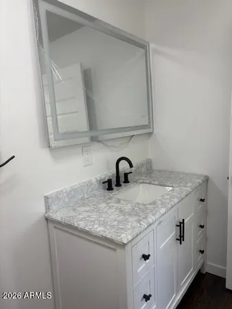 a bathroom with a granite countertop sink and a mirror