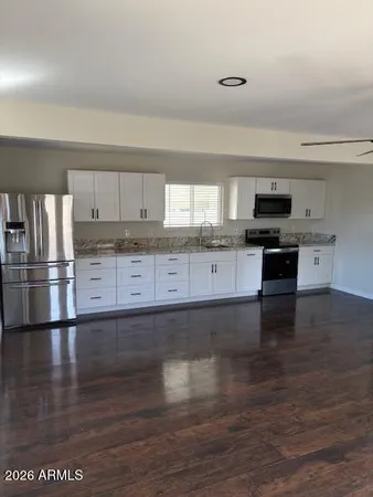 a kitchen with granite countertop a stove and cabinets
