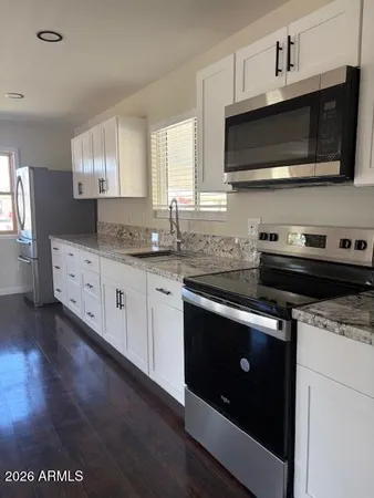 a kitchen with stainless steel appliances a stove microwave and sink