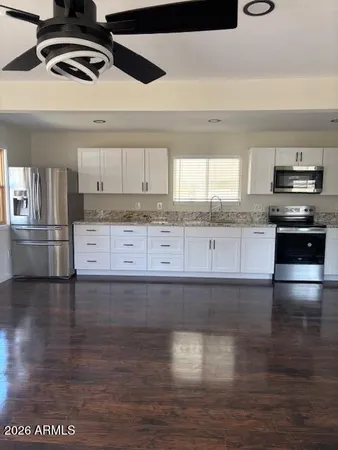 a kitchen with granite countertop a stove and a wooden floor