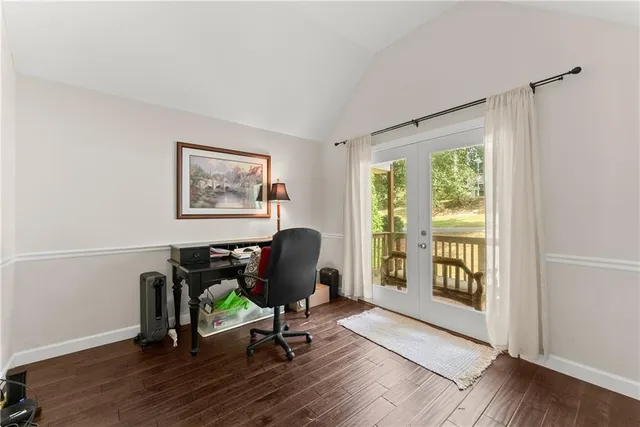 a view of a workspace with wooden floor and a window