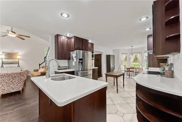 a kitchen with stainless steel appliances kitchen island granite countertop a sink and chairs