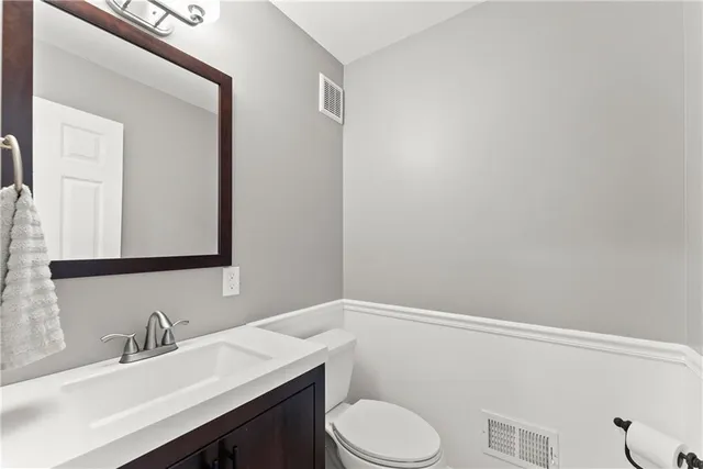 a bathroom with a sink vanity mirror and toilet