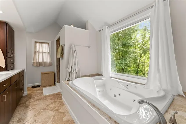 a spacious bathroom with a tub sink and mirror