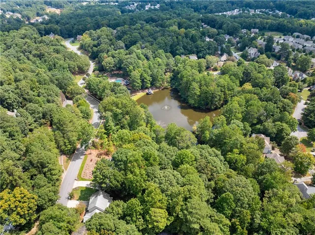 an aerial view of a house with a garden and lake view